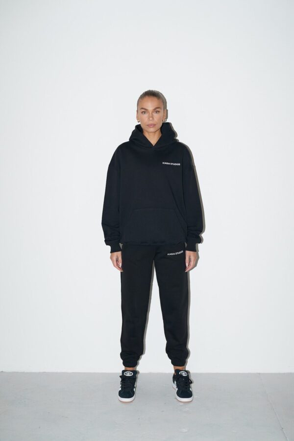 Women's black streetwear core sweatpants with white print on the front left leg. Featuring an elasticated waistband and patch pocket o the rear.