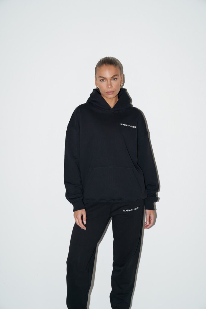 Women's black oversized hoodie with white print on left chest and on the back.